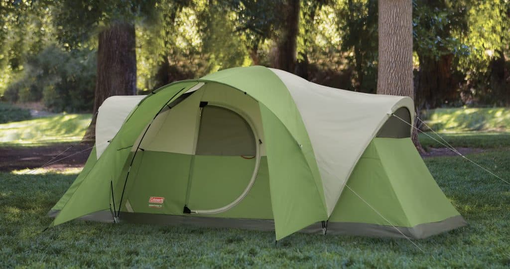 Best Family Camping Tents 2025: Medium Price Range 7 Bright green camping tent set up in a forested area with tall trees and lush grass, ideal for outdoor adventure and camping trips.